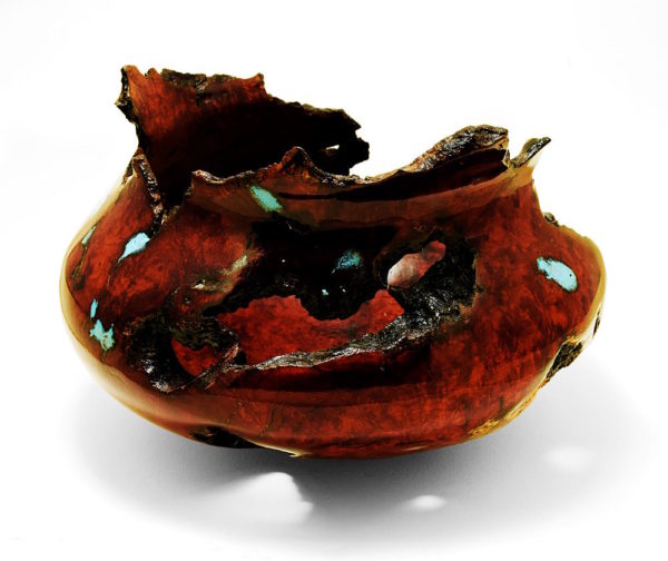 A deep red-brown burl wood turning with turquoise inlay