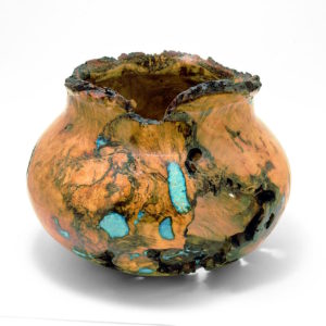 A burl wood turning featuring turquoise inlay