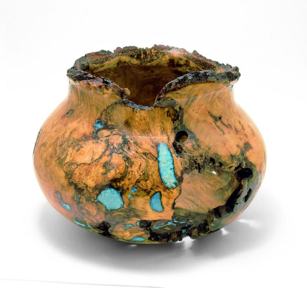 A burl wood turning featuring turquoise inlay