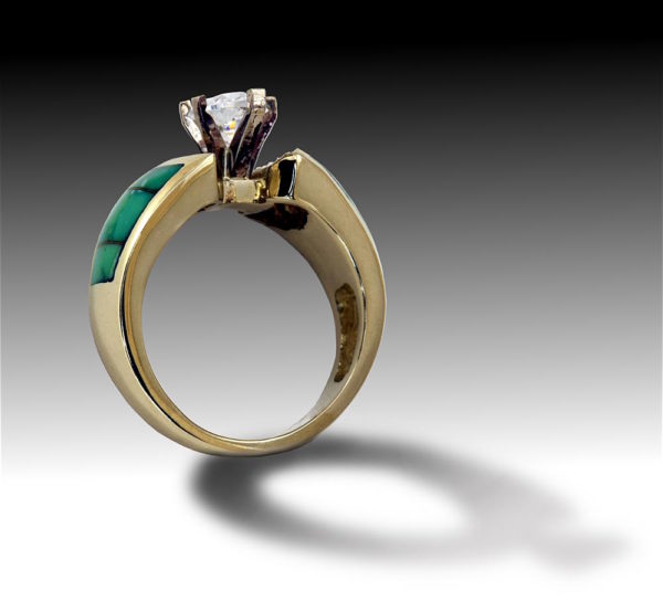 Three quarter view of gold ring with diamonds and turquois inlay