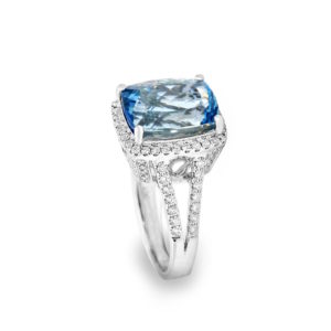 A large aquamarine stone on a ring surrounded by diamonds