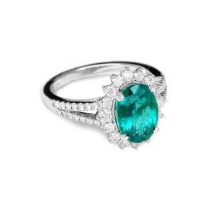 A white gold womens ring with a large emerald and small round diamonds
