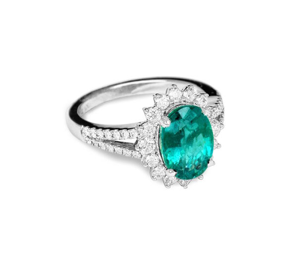 A white gold womens ring with a large emerald and small round diamonds