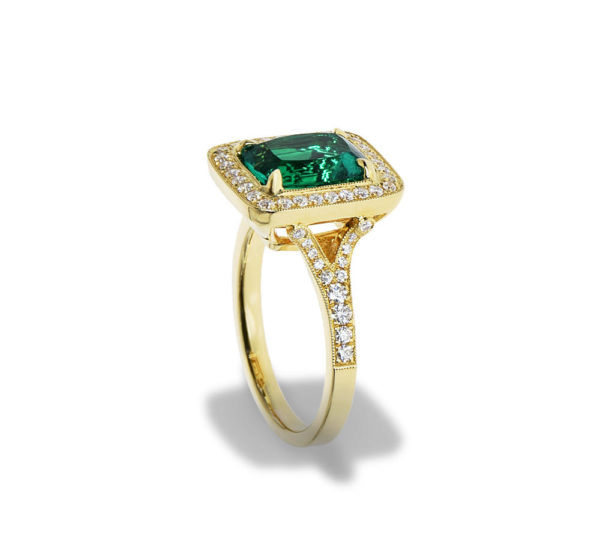 A yellow gold ring with a lrage emerald and diamonds