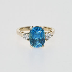 a gold ring with diamonds and zircon gemstone