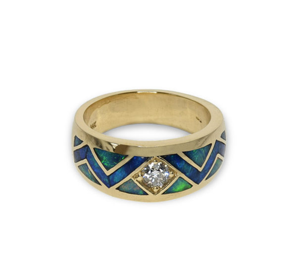 A Gold band featuring a center diamond and opal inlay